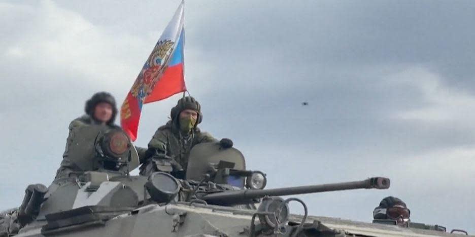 Russian forces ride a tank during their invasion of Ukraine. / Credit: Russian military handout
