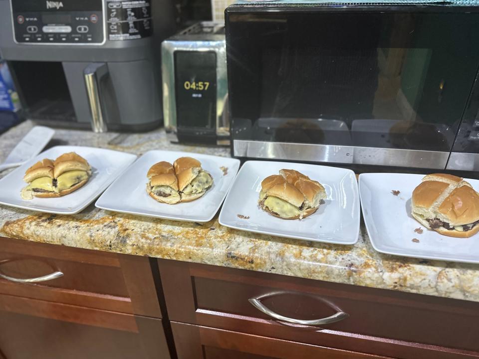 four quartered hamburgers lined up on a kitchen counter