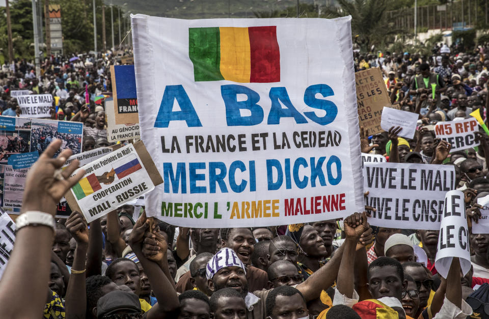 Malians supporting the recent overthrow of President Ibrahim Boubacar Keita gather to celebrate in the capital Bamako, Mali Friday, Aug. 21, 2020. Hundreds marched in the streets of Mali's capital Friday to celebrate the overthrow of Keita, as the West African country's longtime political opposition backed the military's junta plan to eventually hand over power to a civilian transitional government. Main banner in French reads "Down with France and ECOWAS, Thank you Dicko, Thank you to the Malian Army" referring to Mahmoud Dicko, an imam who has helped lead the movement against Keita. (AP Photo)