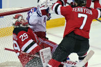 New York Rangers' Alexis Lafrenière, center, is pushed into New Jersey Devils goaltender Mackenzie Blackwood, left, after scoring a goal during the second period of the NHL hockey game in Newark, N.J., Sunday, April 18, 2021. (AP Photo/Seth Wenig)
