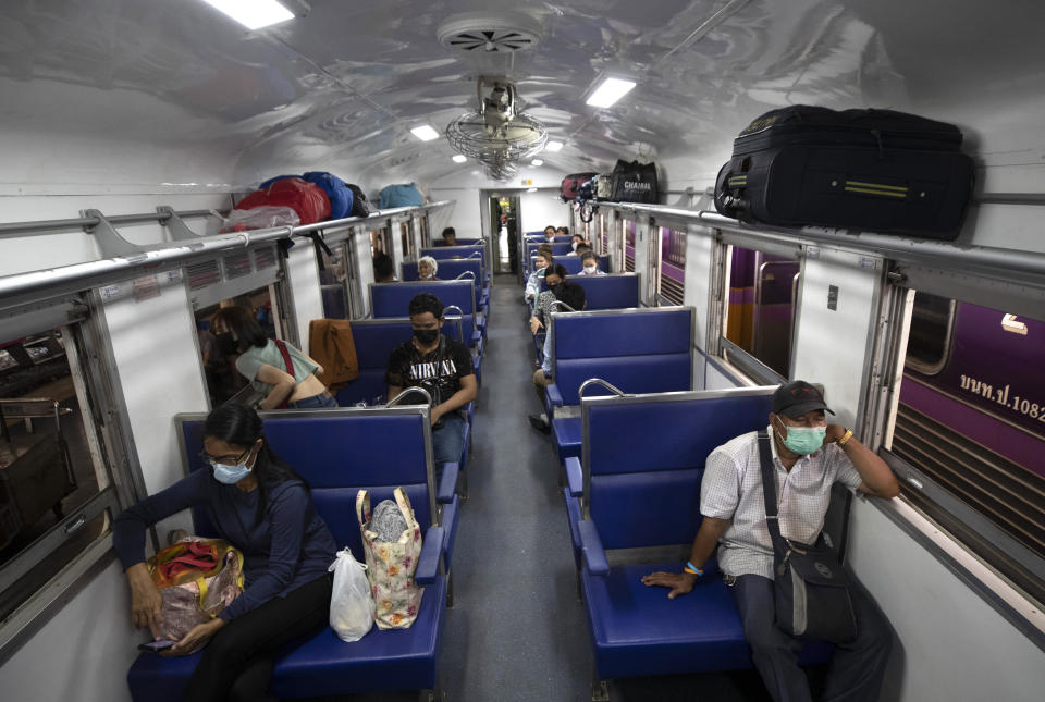 Passengers wear face masks on a train bound for northeastern province of Ubon Ratchathani, at Hua Lamphong Railway Station in Bangkok, Thailand, Friday, April 9, 2021. Thai authorities were struggling Friday to contain a growing coronavirus outbreak just days before the country's traditional Songkran New Year's holiday, when millions of people travel around the country. (AP Photo/Sakchai Lalit)