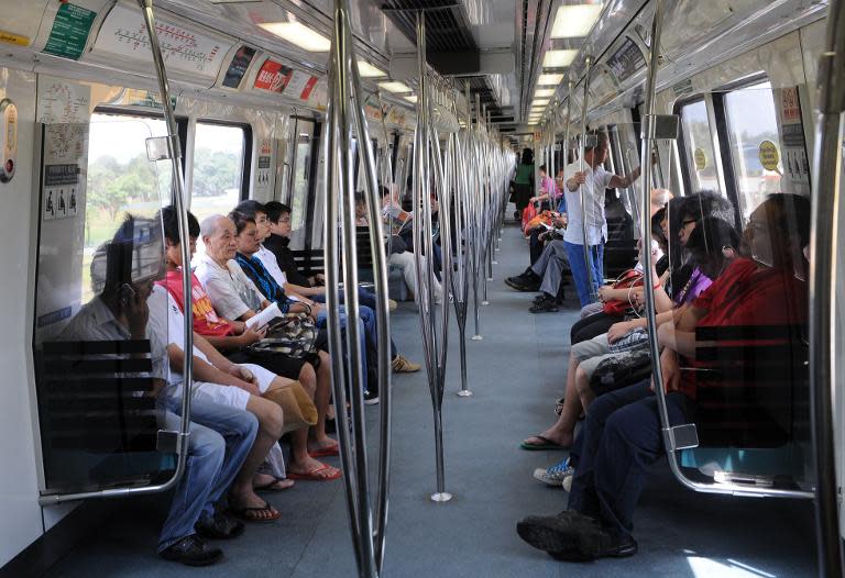 Commuters ride on the Singapore Mass Rapid transit (SMRT) train in Singapore on January 12, 2010