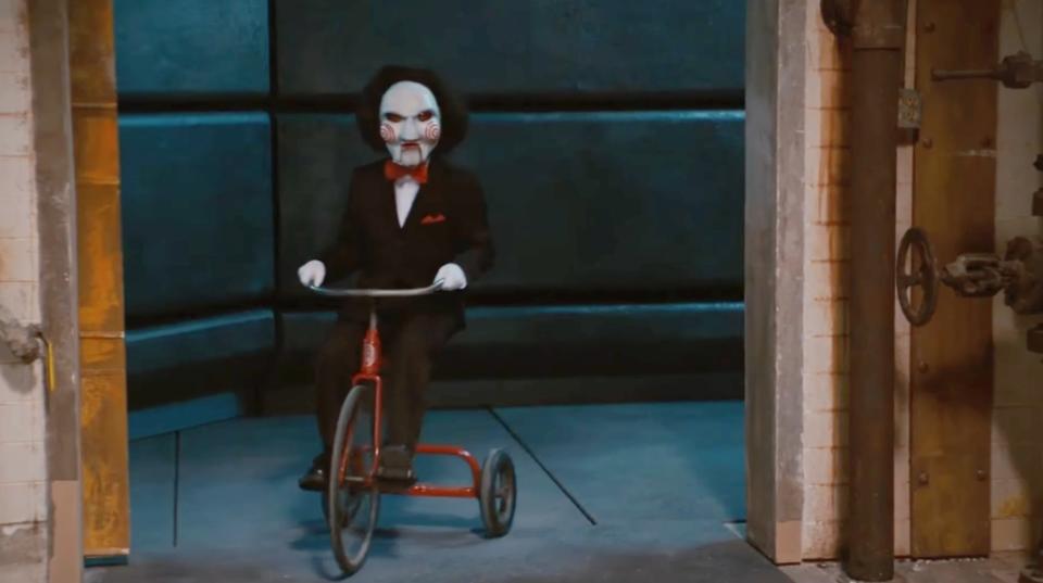 Jigsaw from "Scary Movie 4" is riding a tricycle