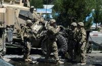 NATO soldiers at the scene of a suicide car bomb attack that targeted foreign military vehicles in Kabul on June 30, 2015