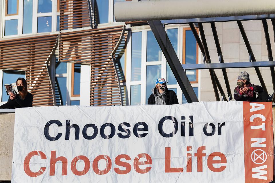 Extinction Rebellion activists protest on the roof of the Scottish parliament in October 2020Getty