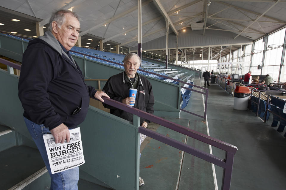 Ron Tenski and Jerry Moritz, left, who had arrived to Fonner Park in Grand Island, Neb., for the horse races, Saturday, March 14, 2020, leave after the races were called off due to dangerous track conditions following snowfall. Fonner was one of the few sporting venues in the country open to fans Saturday, and Moritz wasn't going to let concerns over the new coronavirus stop him from going to the track. "If we had a dozen people in the hospital here and two or three died, then I would probably back off," he said. "I feel like some people probably got it and don't even know it and are already over it." (AP Photo/Nati Harnik)