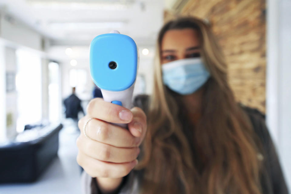 Pariss Boseley-Yemm holds a thermometer at the reopening of The Salon Leeds