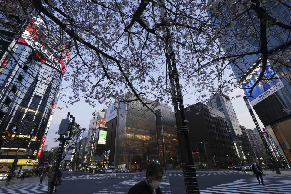Pedestrians walk at usually busy street in Ginza shopping district Tuesday, April 7, 2020, in Tokyo. Japanese Prime Minister Shinzo Abe declared a state of emergency on Tuesday for Tokyo and six other prefectures to ramp up defenses against the spread of the coronavirus. (AP Photo/Eugene Hoshiko)