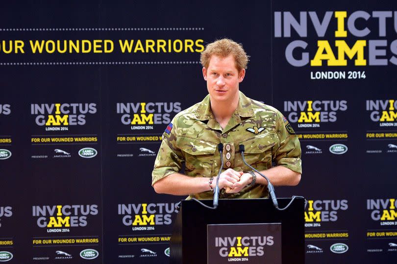 Harry in military fatigues speaking from a podium as he launched the Invictus Games in London in 2014