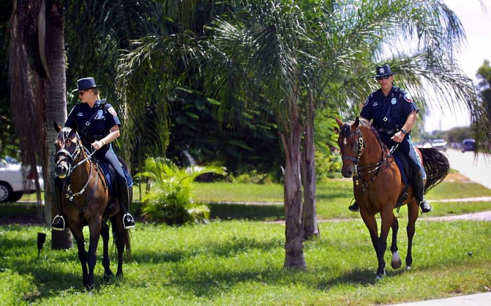 En esta foto de 2001, los agentes de policía de Pembroke Pines Terry Burns, izquierda, y Ed Klingman, ambos de la Unidad Montada, deambulan hacia el oeste por Johnson Street en Pembroke Pines en busca de evidencia relacionada con un atraco a un banco.