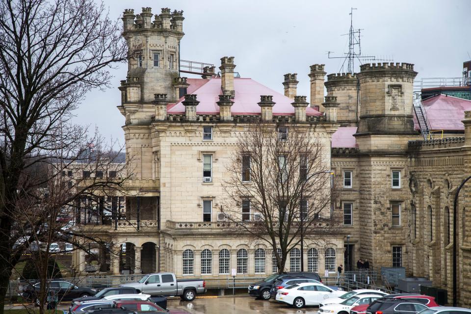 People stand outside a staff entrance at the Anamosa State Penitentiary, Tuesday, March 23, 2021, in Anamosa, Iowa.