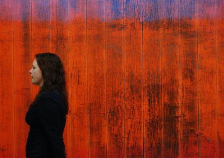 An employee poses with a detail of artist Gerhard Richter's artwork "Wand (Wall)" at Sotheby's auction house in London January 29, 2014. REUTERS/Luke MacGregor