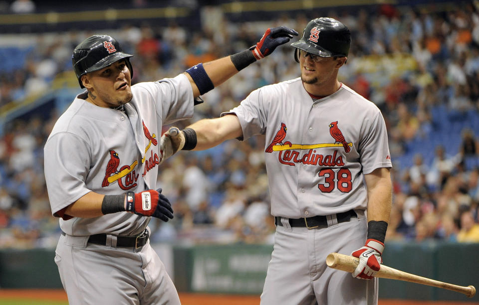 FILE - In this July 3, 2011, file photo, St. Louis Cardinals' Yadier Molina, left, celebrates at the plate with teammate Mark Hamilton after hitting a solo home run off of Tampa Bay Rays pitcher Jeremy Hellickson during the second inning of a baseball game in St. Petersburg, Fla. In baseball history, plenty of guys have drawn the nickname of Doc -- Dwight Gooden and Roy Halladay, among them. On Friday, April 10, 2020, under an accelerated schedule prompted by dire circumstances, former big leaguer Mark Hamilton is set to graduate a month early from medical school on Long Island. (AP Photo/Brian Blanco, File)