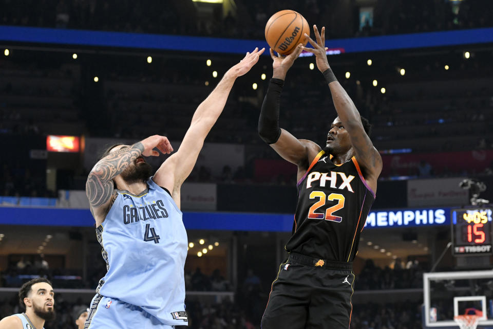 Phoenix Suns center Deandre Ayton (22) shoots against Memphis Grizzlies center Steven Adams (4) in the first half of an NBA basketball game Monday, Jan. 16, 2023, in Memphis, Tenn. (AP Photo/Brandon Dill)