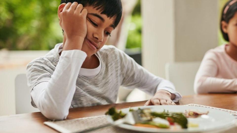 Shot of children looking at vegetables on a plate that they are expected to eat