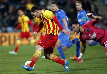 Barcelona's Lionel Messi (L) scores his second goal against Getafe's Jordi Codina during their Spanish King's Cup soccer match at Colisseum Alfonso Perez stadium in Getafe January 16, 2014. REUTERS/Sergio Perez