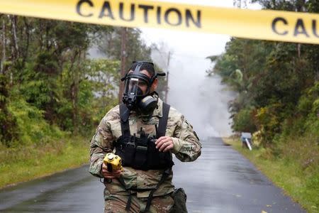 Lieutenant Aaron Hew Lew, of the Hawaii National Guard, measures levels of toxic sulfur dioxide gas near a lava flow in the Leilani Estates subdivision during ongoing eruptions of the Kilauea Volcano, Hawaii, U.S., May 8, 2018. REUTERS/Terray Sylvester