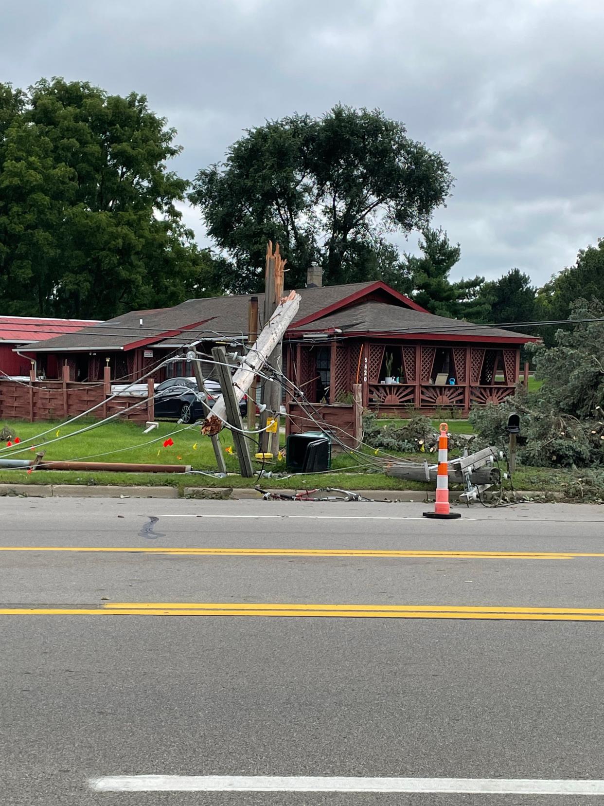 A utility pole is snapped in half in the 5400 block of S. Martin Luther King Jr. Boulevard in south Lansing on Saturday, Aug. 26, 2023.