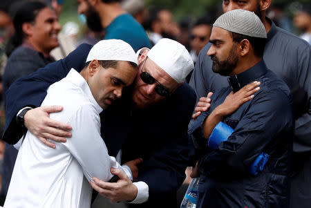 FILE PHOTO: People comfort each other before the Friday prayers at Hagley Park outside Al-Noor mosque in Christchurch, New Zealand March 22, 2019. REUTERS/Edgar Su/File Photo