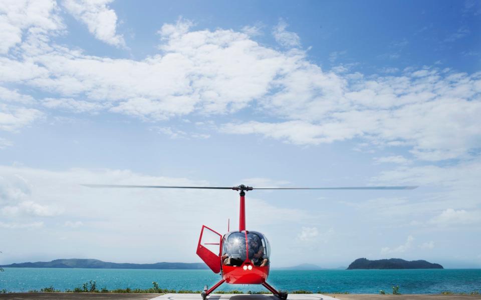 Helicopter lands on a helipad on a tropical island