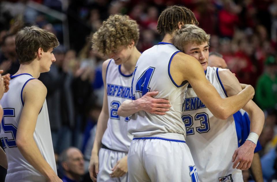 Wyoming Tri-unity Christian's Trey Rillema (14) hugs his teammate and Owen Rosendall (23) after defeating Mt. Pleasant Sacred Heart 79-59 during the MHSAA Div. 4 state finals at the Breslin Center in East Lansing on March 16, 2024.