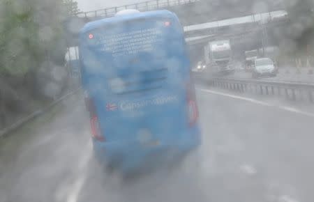 FILE PHOTO: The Conservative Party campaign bus is seen travelling through heavy rain on the M6 motorway in central England May 6, 2015. REUTERS/Toby Melville/File Photo