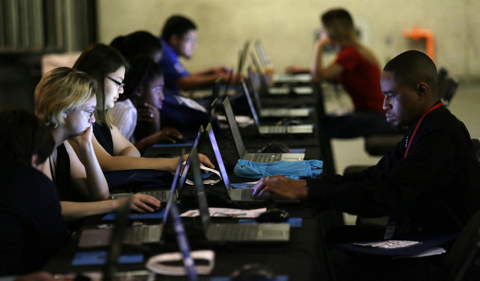 Job seekers work on their resumes during the Opportunity Fair and Forum employment event in Dallas. (AP Photo/LM Otero)