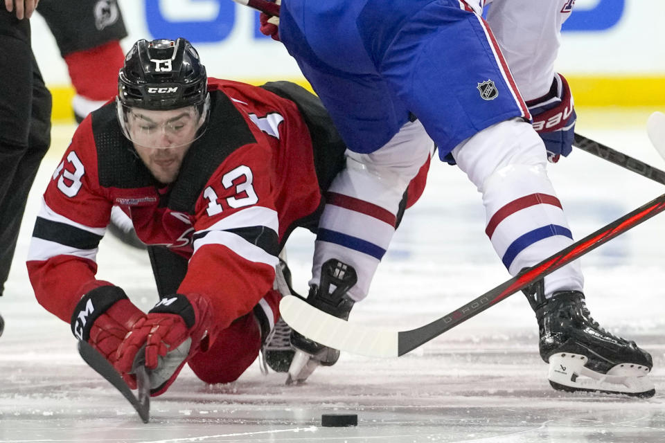 New Jersey Devils center Nico Hischier (13) dives for the puck during the second period of an NHL hockey game against the Montreal Canadiens, Saturday, Feb. 24, 2024, in Newark, N.J. (AP Photo/Mary Altaffer)