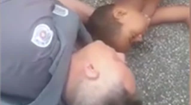 The comforting police man stayed with the boy till the ambulance arrived. Photo: LiveLeak