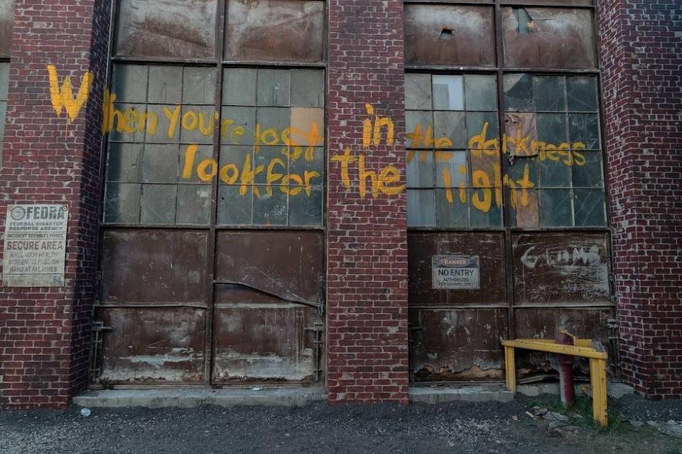 Graffiti of the Fireflies slogan, "When you're lost in darkness, look for the light" from The Last of Us.