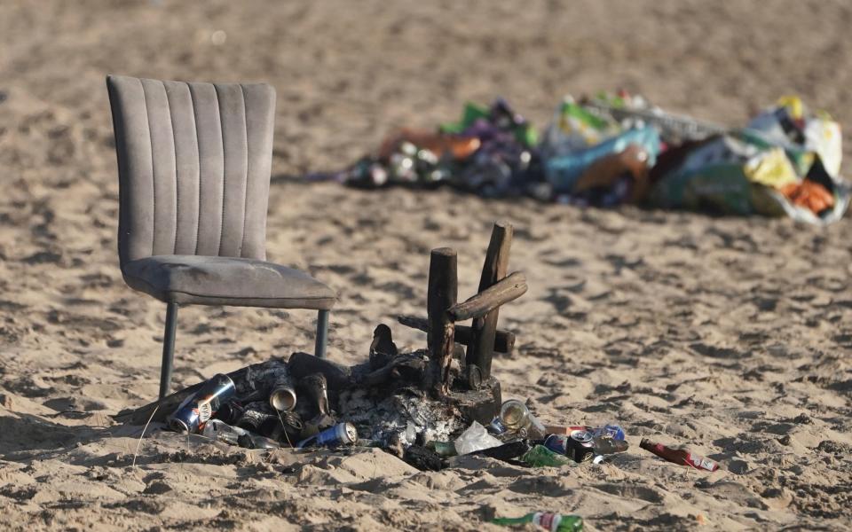 A discarded chair next to a burnt-out barbecue on Tynemouth beach in north east England - Owen Humphreys/PA