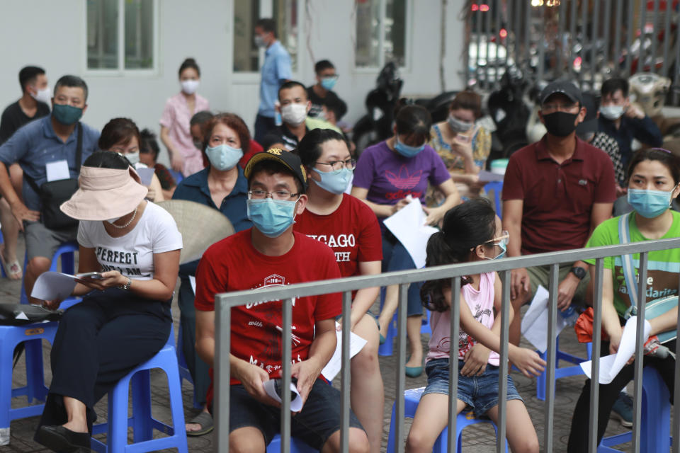 People wait in line for COVID-19 test in Hanoi, Vietnam, Friday, July 31, 2020. Vietnam reported on Friday the country's first ever death of a person with the coronavirus as it struggles with a renewed outbreak after 99 days without any cases. (AP Photo/Hau Dinh)