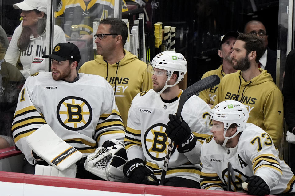 Boston Bruins goaltender Jeremy Swayman (1), defenseman Brandon Carlo, center, and defenseman Charlie McAvoy (73) watch from the bench during the third period of Game 2 against the Florida Panthers of a second-round series of the NHL hockey Stanley Cup playoffs Wednesday, May 8, 2024, in Sunrise, Fla. (AP Photo/Lynne Sladky)