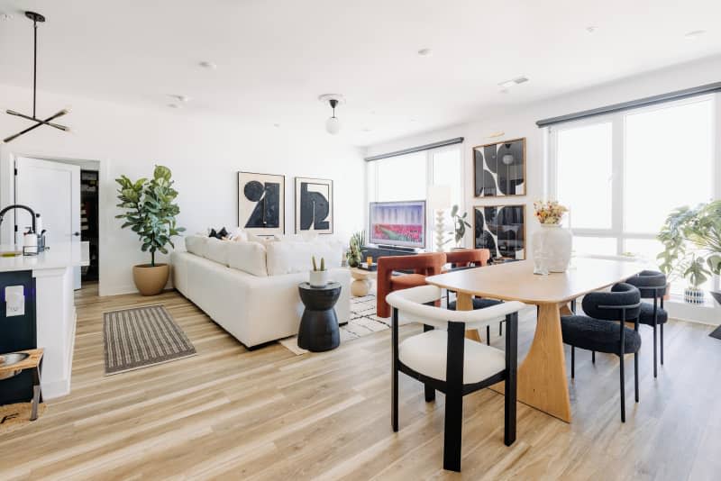 white living room with white sofa, black, neutral and white decor, and lots of curved edge furniture