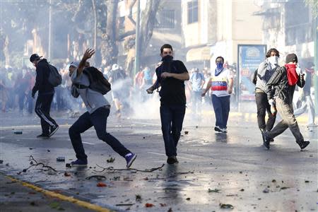 Opposition demonstrators throw stones against riot police during a protest against President Nicolas Maduro's government in Caracas February 15, 2014. REUTERS/Carlos Garcia Rawlins