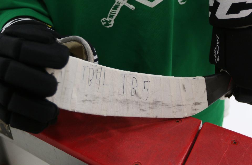 Wayland High sophomore Sam Brande's hockey stick now has "TB4L TB5" written on it to honor his friend Teddy Balkind. It stands for "Teddy Balkind For Life, Teddy Balkind 5" as No. 5 was the uniform number of Balkind who recently died in a tragic hockey incident. Brande displays his hockey stick before practice, Jan. 14, 2022.