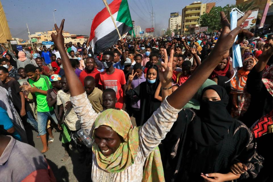 Protesters in Sudan carry national flags