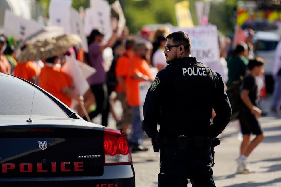 A Uvalde police officer watches as victims’ families demand answers and accountability (Copyright 2022 The Associated Press. All rights reserved)