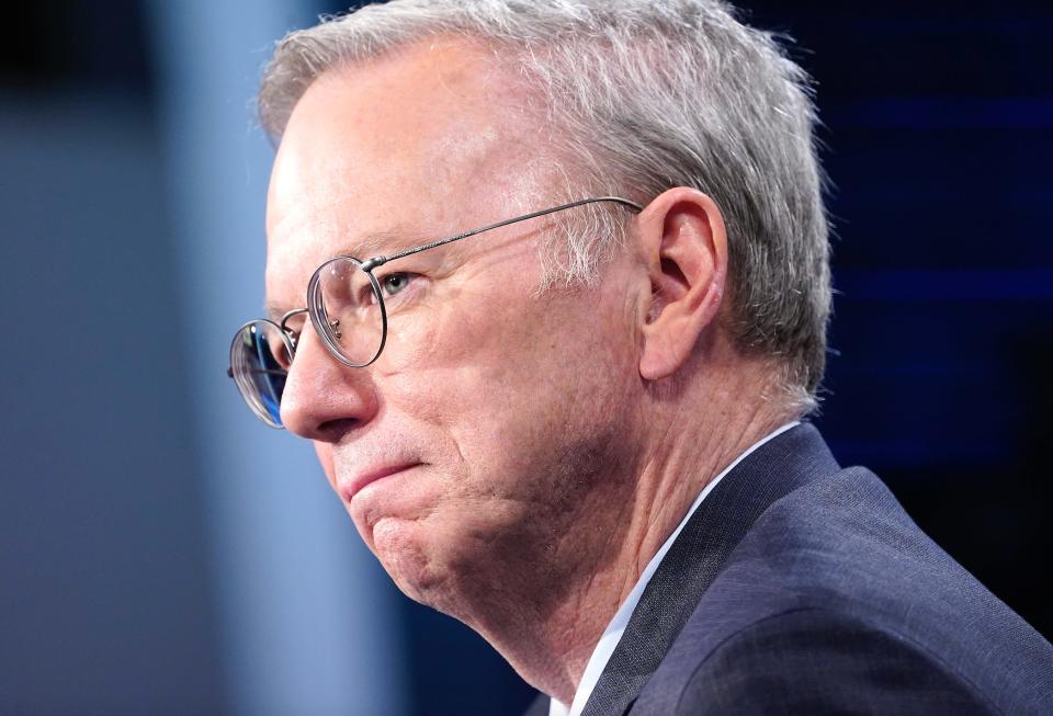 Eric Schmidt side photo of him wearing glasses and a suit with his lips pursed