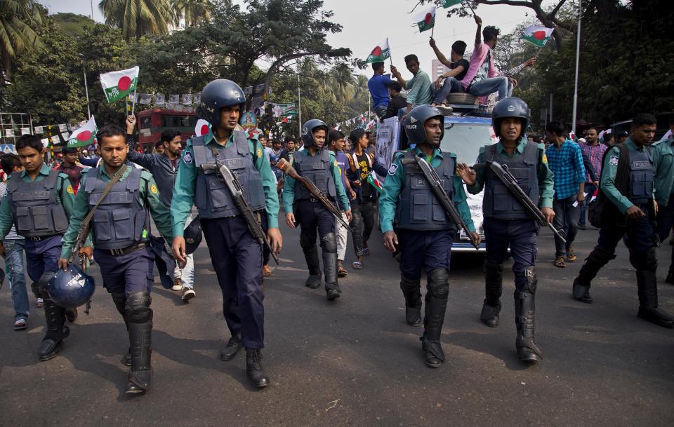 Bangladeshi policemen escort Bangladesh Awami League party election rally in Dhaka, Bangladesh, Thursday, Dec. 27, 2018. Bangladesh heads for the 11th National Parliamentary Election on Dec. 30, amid opposition allegations that thousands of its leaders and activists have been arrested to weaken them. But authorities say the arrests are not politically motivated and the opposition is trying to create chaos ahead of elections. (AP Photo/Anupam Nath)