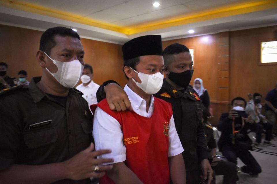 Indonesian teacher Herry Wirawan (C) is escorted prior to his trial at a court in Bandung, West Java on Feb. 15, 2022. In April, he was sentenced to death for the rape of at least 13 students, all minors.<span class="copyright">Timur Matahari–AFP/Getty Images</span>
