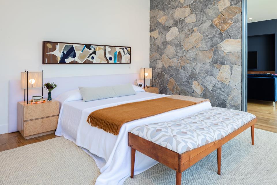 An artwork by Nicole Strickland Botto hangs above a custom bed frame wrapped in a Perennials white linen. A vintage, Charlotte Perriand–inspired daybed is covered in a Serena Dugan’s Fenn fabric. Design Frères burl wood nightstands and Lawson-Fenning Topanga table lamps flank the bed.