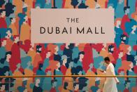 An Emirati man walks in a largely empty Dubai Mall while wearing a surgical mask over the coronavirus pandemic in Dubai, United Arab Emirates, Monday, May 11, 2020. Malls have opened back up across Dubai and the rest of the United Arab Emirates despite facing an ever-growing number of infections, part of efforts to stimulate the country's already-strained economy. (AP Photo/Jon Gambrell)