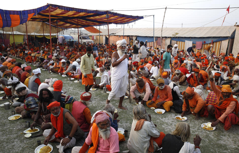 Devotees and pilgrims eat at a free food camp, at Sangam, during Magh Mela festival, in Prayagraj, India. Friday, Feb. 19, 2021. Millions of people have joined a 45-day long Hindu bathing festival in this northern Indian city, where devotees take a holy dip at Sangam, the sacred confluence of the rivers Ganga, Yamuna and the mythical Saraswati. Here, they bathe on certain days considered to be auspicious in the belief that they be cleansed of all sins. (AP Photo/Rajesh Kumar Singh)