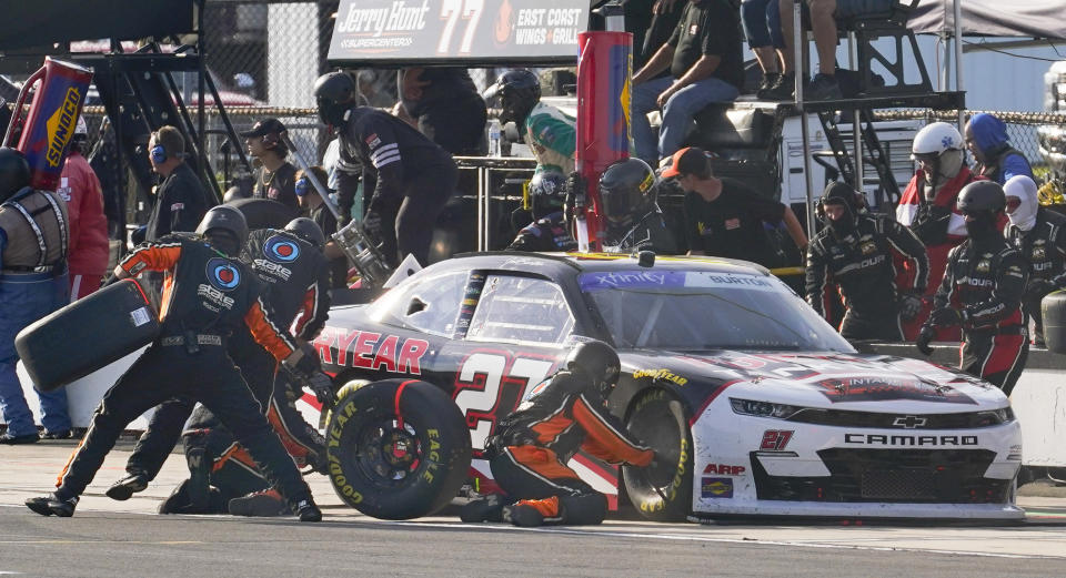 The pit crew works on the car of Jeb Burton (27) during a stop in the NASCAR Xfinity Series auto race at Pocono Raceway, Saturday, July 23, 2022 in Long Pond, Pa. (AP Photo/Matt Slocum)