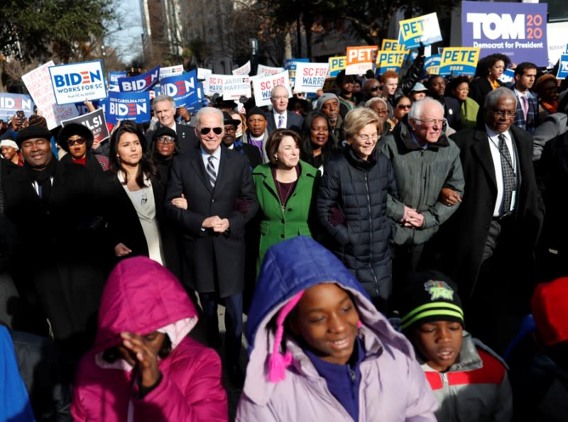 Seven of the democratic U.S. 2020 presidential candidates walk arm-in-arm with local African-American leaders during the Martin Luther King Jr. (MLK) Day Parade in Columbia