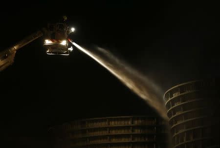 Firemen spray water into one of the cooling towers at Didcot B Power Station in Didcot, western England October 19, 2014. REUTERS/Eddie Keogh