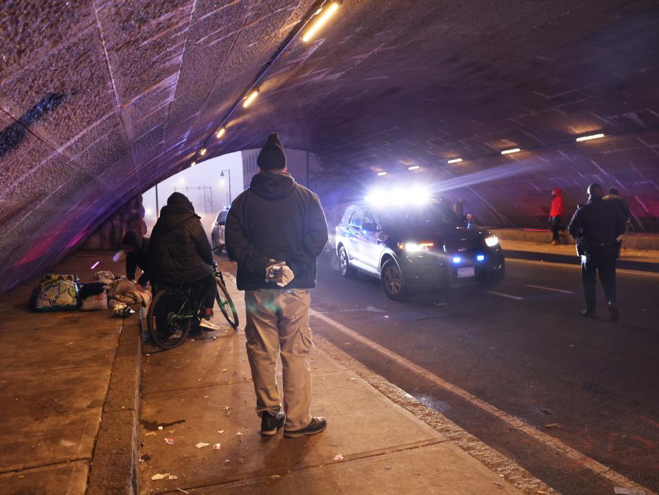 Brockton city workers clean under the School Street bridge where people who are homeless are staying on Tuesday, Dec. 26, 2023.