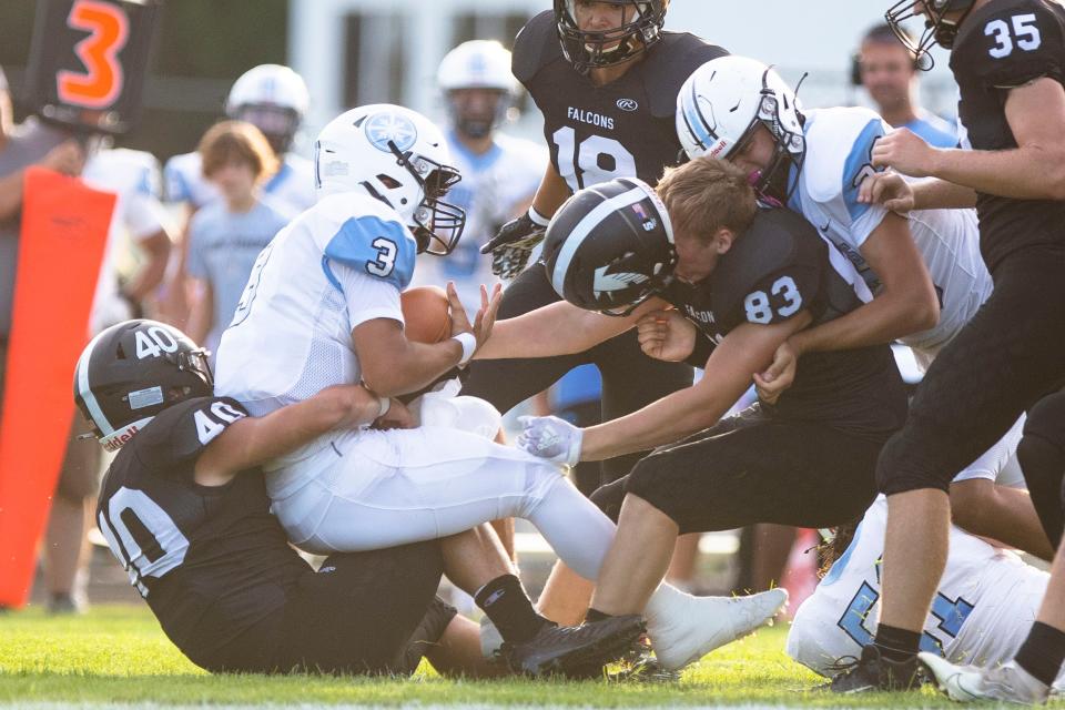 John Glenn's Jaime Gierlowski (40) takes down Saint Joseph's Alex Ortiz (3) as John Glenn's Eli Beeney (83) helmet comes off during the John Glenn vs. Saint Joseph football game Friday, Sept. 2, 2022 at John Glenn High School in Walkerton. 