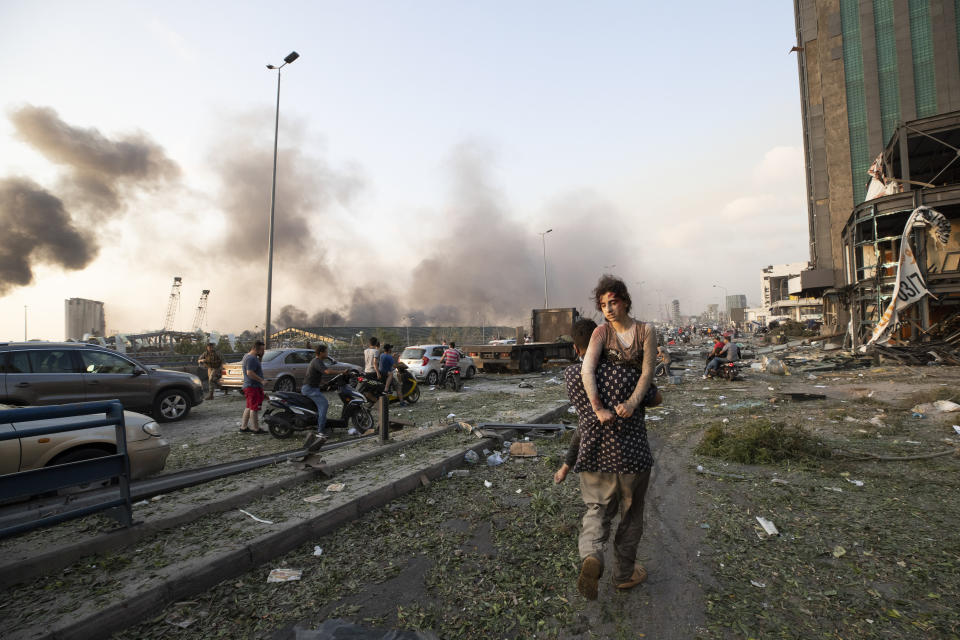 People evacuate the wounded after a massive explosion in Beirut, Lebanon, Tuesday, Aug. 4, 2020. (AP Photo/Hassan Ammar)